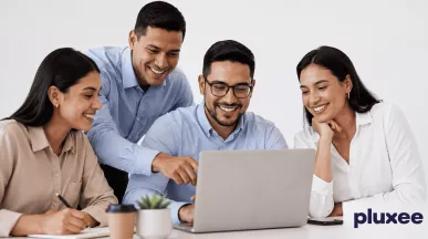Equipo de trabajo colaborando frente a una laptop con actitud positiva y compromiso laboral